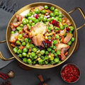 Golden stainless steel wok pan with non-stick surface, filled with stir-fried peas, meat, and vegetables, displaying heirloom