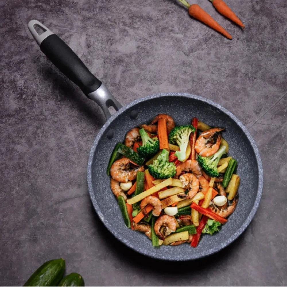GraniteStone Fusion non-stick fry pan with sautéed shrimp and vegetables on gray textured surface, showcasing durability and 