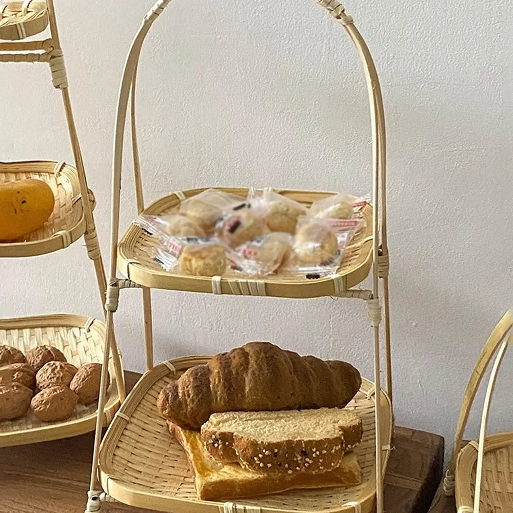 Tiered bamboo basket set displaying bread, pastries, and nuts on white wall background, eco-friendly pantry organization.