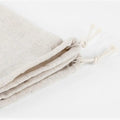 Handmade organic linen bread bags with drawstring closures, displayed in natural cream color for sustainable loaf storage.