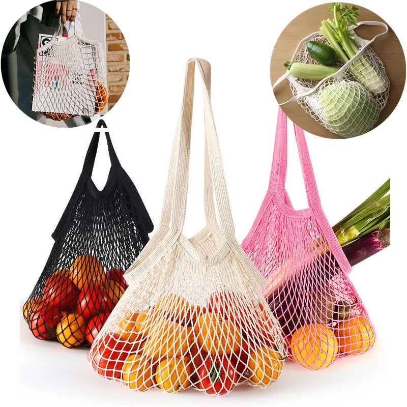 Three colorful cotton mesh produce bags in black, cream, and pink, filled with fresh vegetables and fruits, displayed against