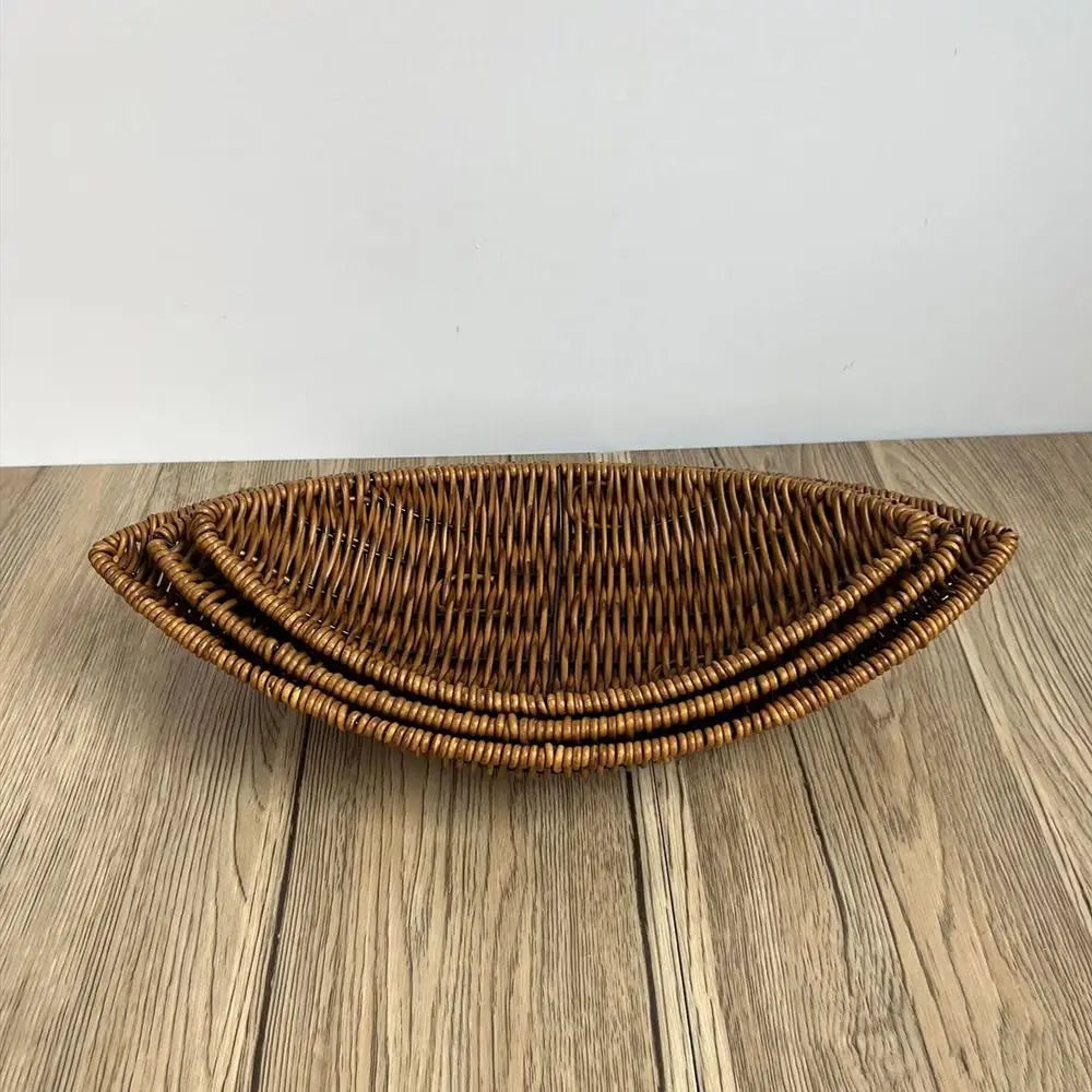 Hand-woven rattan bread basket with natural golden-brown weave and curved sides, displayed on wooden surface.
