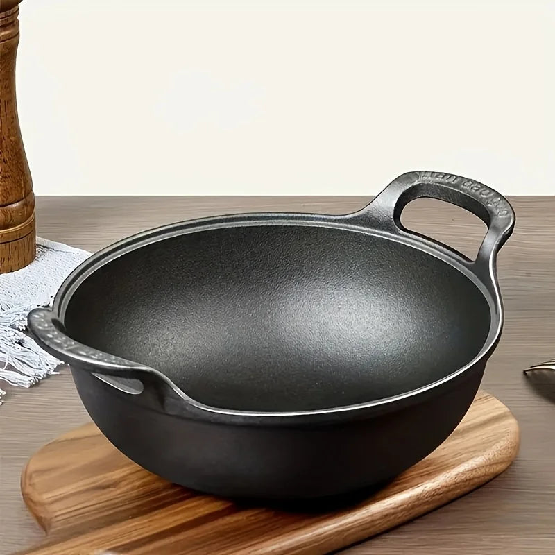 Cast iron double-handle wok with beef and vegetable stir-fry, sesame garnish, surrounded by spices and fresh herbs on wooden 