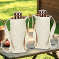 Two insulated copper bottles with cream canvas carriers featuring handles, displayed on outdoor wooden table with green backg