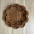 Hand-woven rattan decorative bread basket with scalloped edges on wooden surface, natural tan color