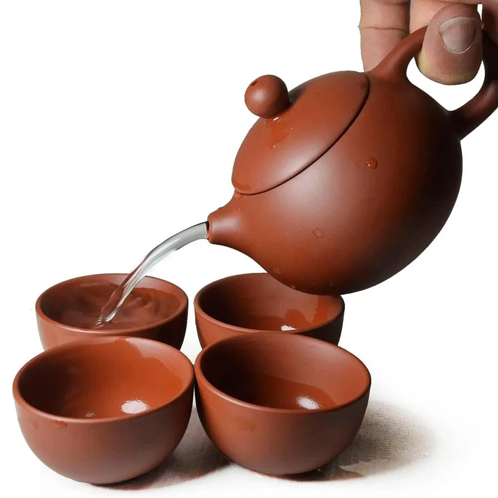 Handmade purple clay teapot pouring tea into matching cups, 200ml capacity, traditional ceramic tea set.