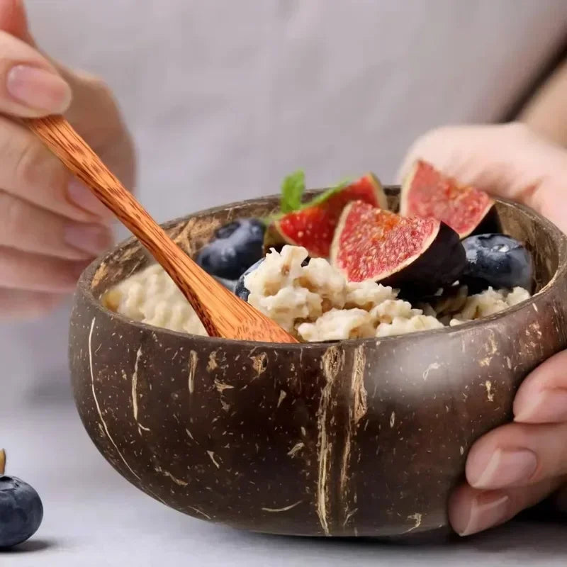Six natural coconut bowls with wooden spoon, one filled with fresh berries and fruit slices, displayed against white backgrou