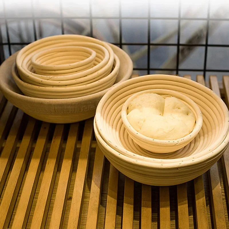 Natural rattan bread proofing baskets in various sizes, handmade bannetons with spiral weave pattern on wooden rack.