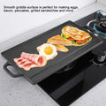Cast iron griddle with smooth surface cooking bacon, eggs, and grilled sandwich on stovetop, featuring dual handles and heat 