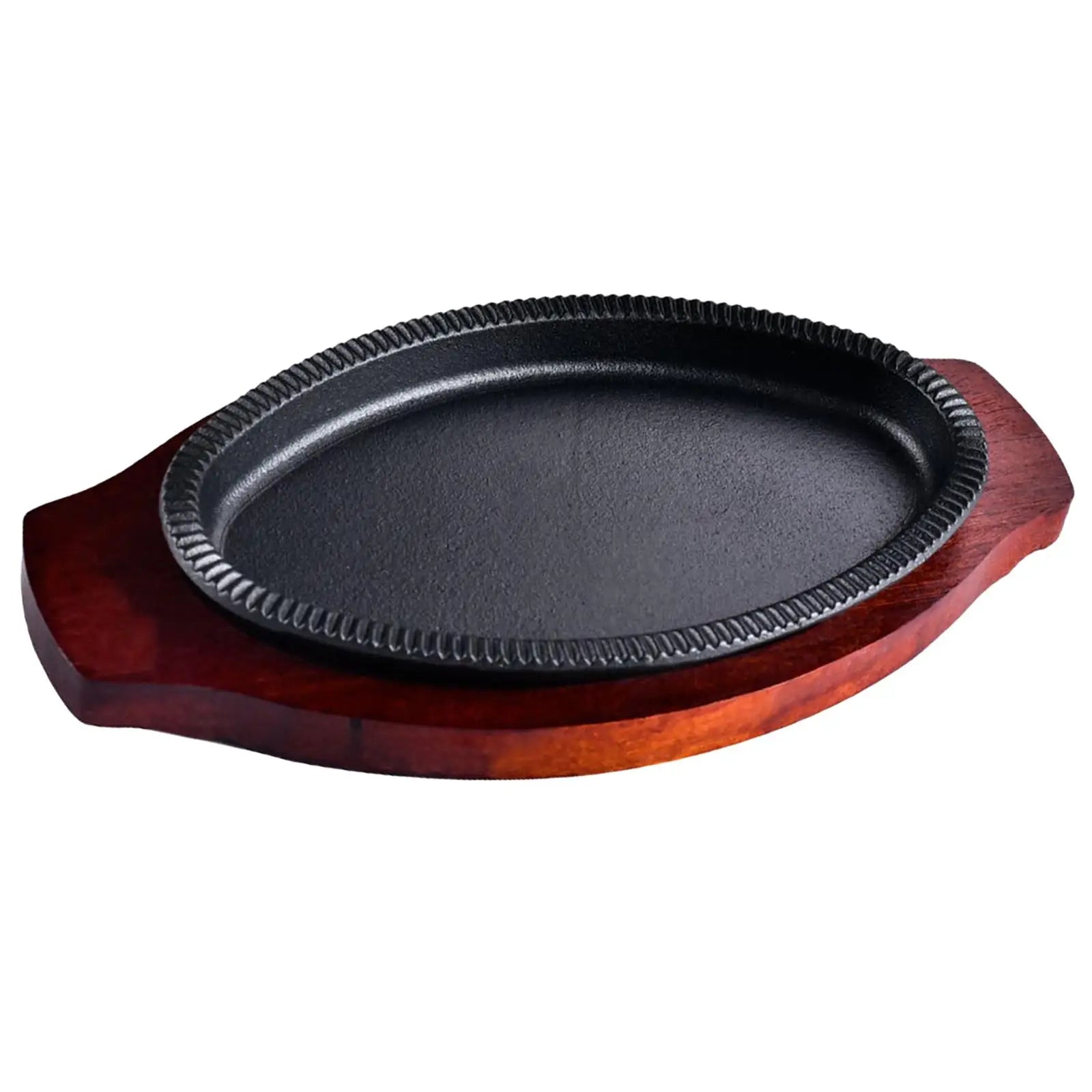 Cast iron fajita griddle pan with decorative rope rim on wooden serving board base