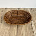Hand-woven rattan bread basket with natural tan finish, 24cm width, displayed on wooden surface with measurement markers.