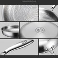 Pure titanium fry pan with hexagonal textured surface, stainless steel handle, and branded lid showing natural non-stick coat