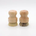 Two wooden dish brushes with natural bristles side by side, featuring replaceable heads and sustainable bamboo handles on whi