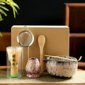 Japanese Matcha Tea Set with bamboo whisk, wooden spoon, ceramic bowl, strainer, and brush in eco-friendly packaging on neutr