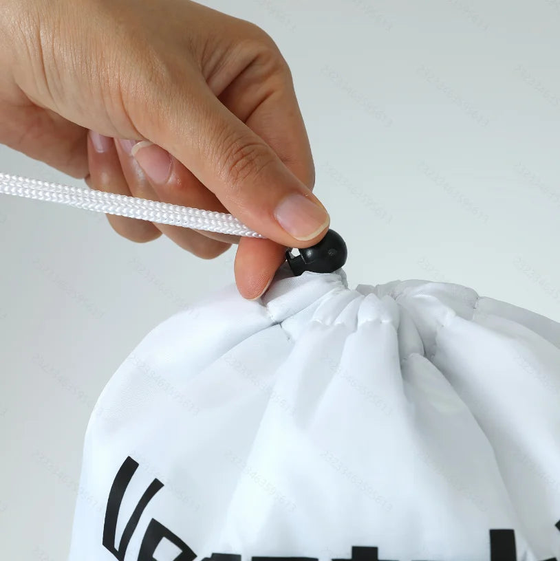 Hand holding white insulated storage bag with black drawstring closure and text detail, showcasing reusable design.