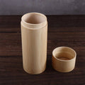 Two handcrafted bamboo tea storage canisters in natural light wood, one tall cylindrical container with decorative band and o