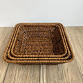 Hand-woven rattan bread basket with natural tan weave pattern and reinforced rim, displayed on wooden surface.