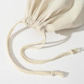 Handmade organic linen bread bag with drawstring closure, displayed flat showing natural cream fabric and braided cord ties.