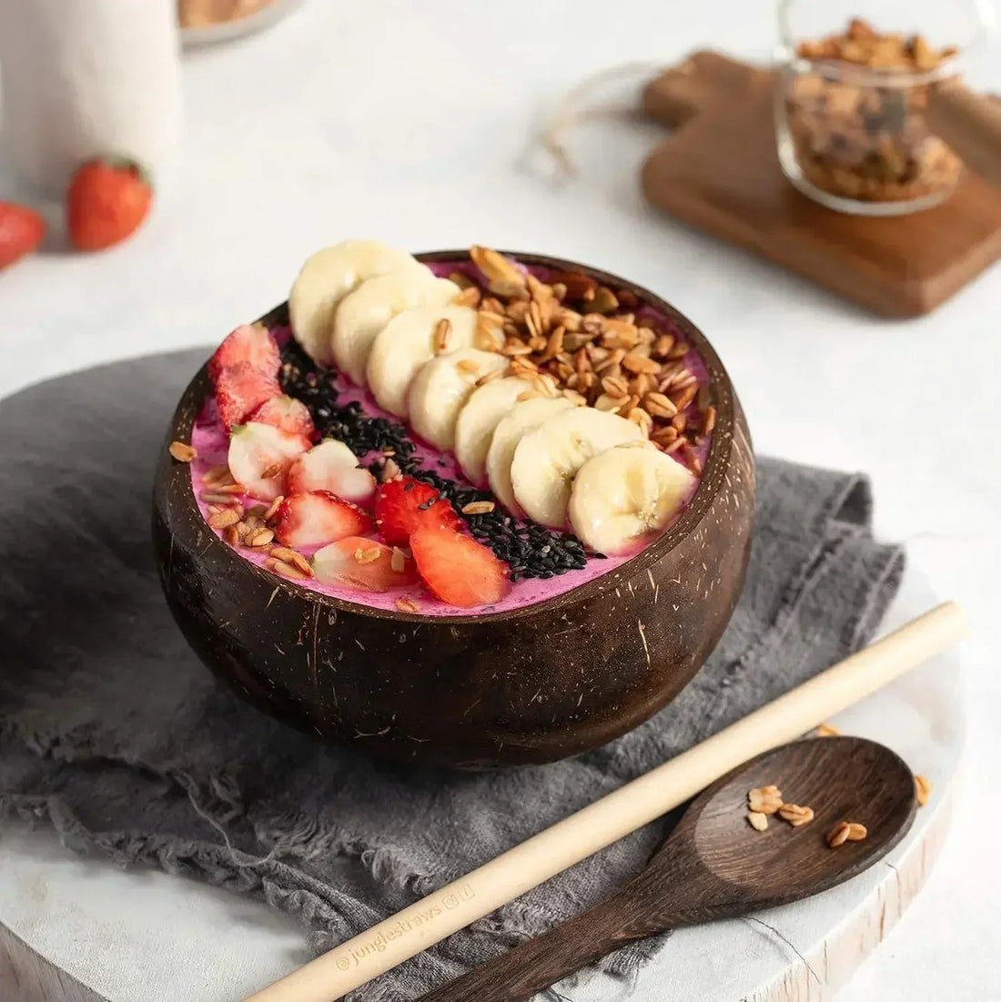 Coconut wood dessert bowl filled with acai, berries, banana slices, and granola; artisan handcrafted serving set.