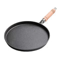 Black cast iron skillet with wooden handle and metal band, perfect for cooking eggs and breakfast foods.