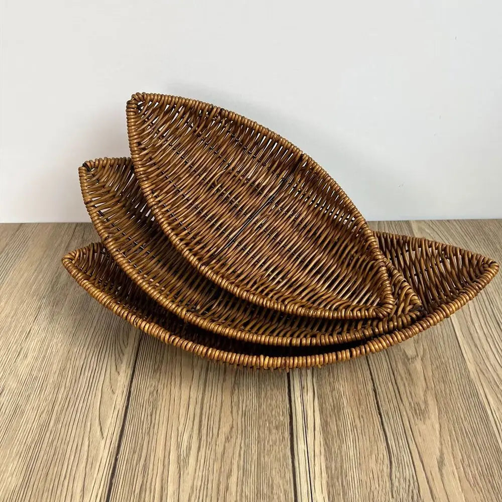 Hand-woven rattan bread baskets in natural brown, stacked nested display showing woven texture and oval leaf shape design.