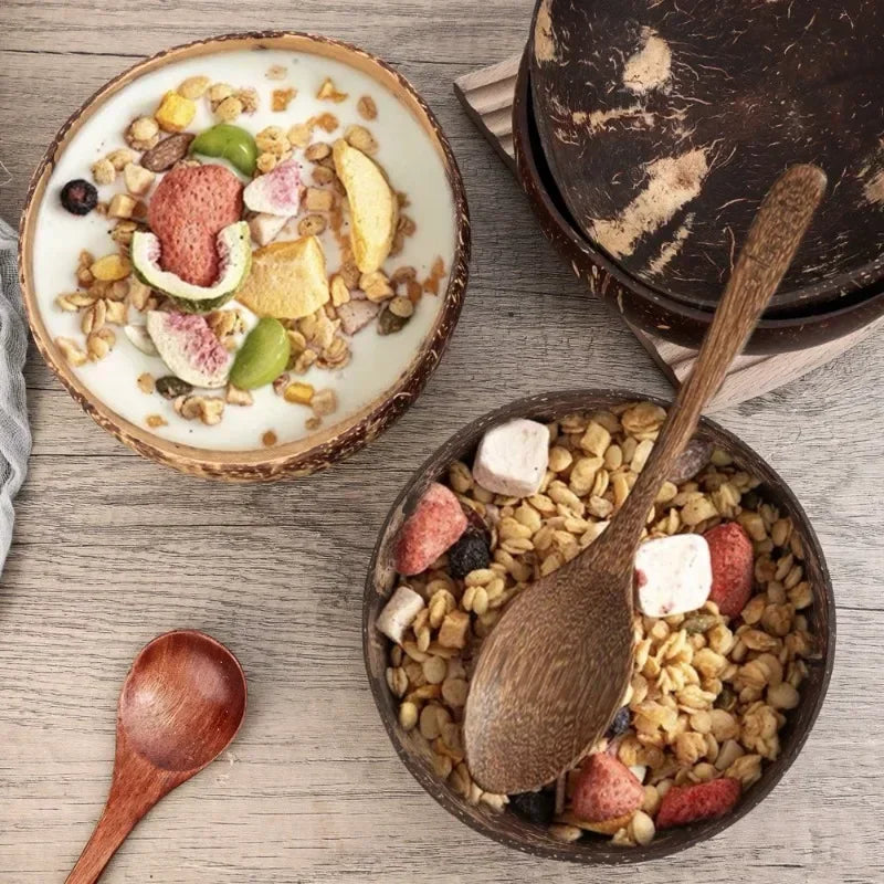 Handcrafted wooden serving bowl filled with granola, fresh fruit, and yogurt on rustic wooden surface with wooden spoon.