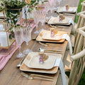 Eco-friendly palm leaf plates in natural wood tones displayed on an elegant table setting with gold cutlery, crystal glasses,