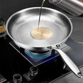 Pure titanium fry pan with oil being poured in, showing natural non-stick surface on induction cooktop, eco-friendly cookware