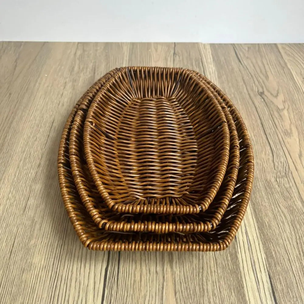 Hand-woven rattan bread basket in natural brown, nested set of three, displayed on wooden surface.