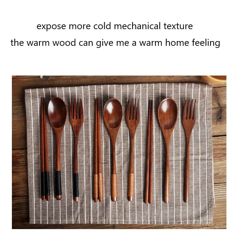 Wooden cutlery set with spoons, forks, and chopsticks arranged on striped linen cloth over wooden surface.