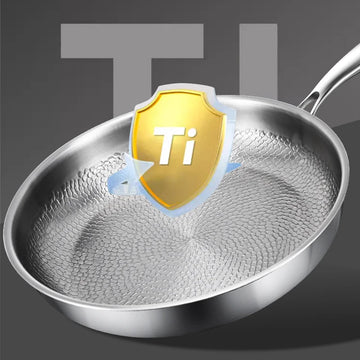 Pure titanium heritage fry pan with honeycomb texture surface and protective Ti shield badge, stainless steel handle against 