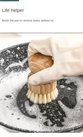 Wooden natural dish brush with coconut fibre bristles cleaning a dark pan with soapy water, demonstrating oil-free stain remo