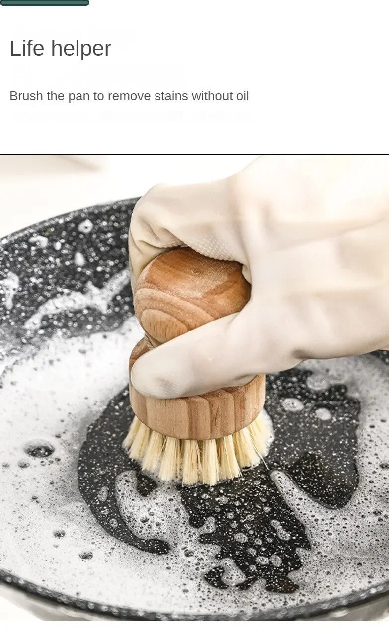 Wooden natural dish brush with coconut fibre bristles cleaning a dark pan with soapy water, demonstrating oil-free stain remo