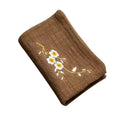 Brown organic cotton cleaning cloth with embroidered white daisies and gold stems, folded display