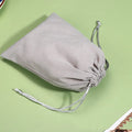 Beige cotton mesh produce bag with drawstring closure displayed flat on green background, eco-friendly reusable grocery tote.