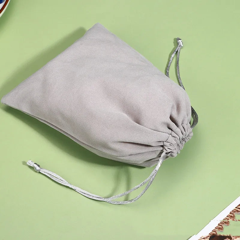 Beige cotton mesh produce bag with drawstring closure displayed flat on green background, eco-friendly reusable grocery tote.