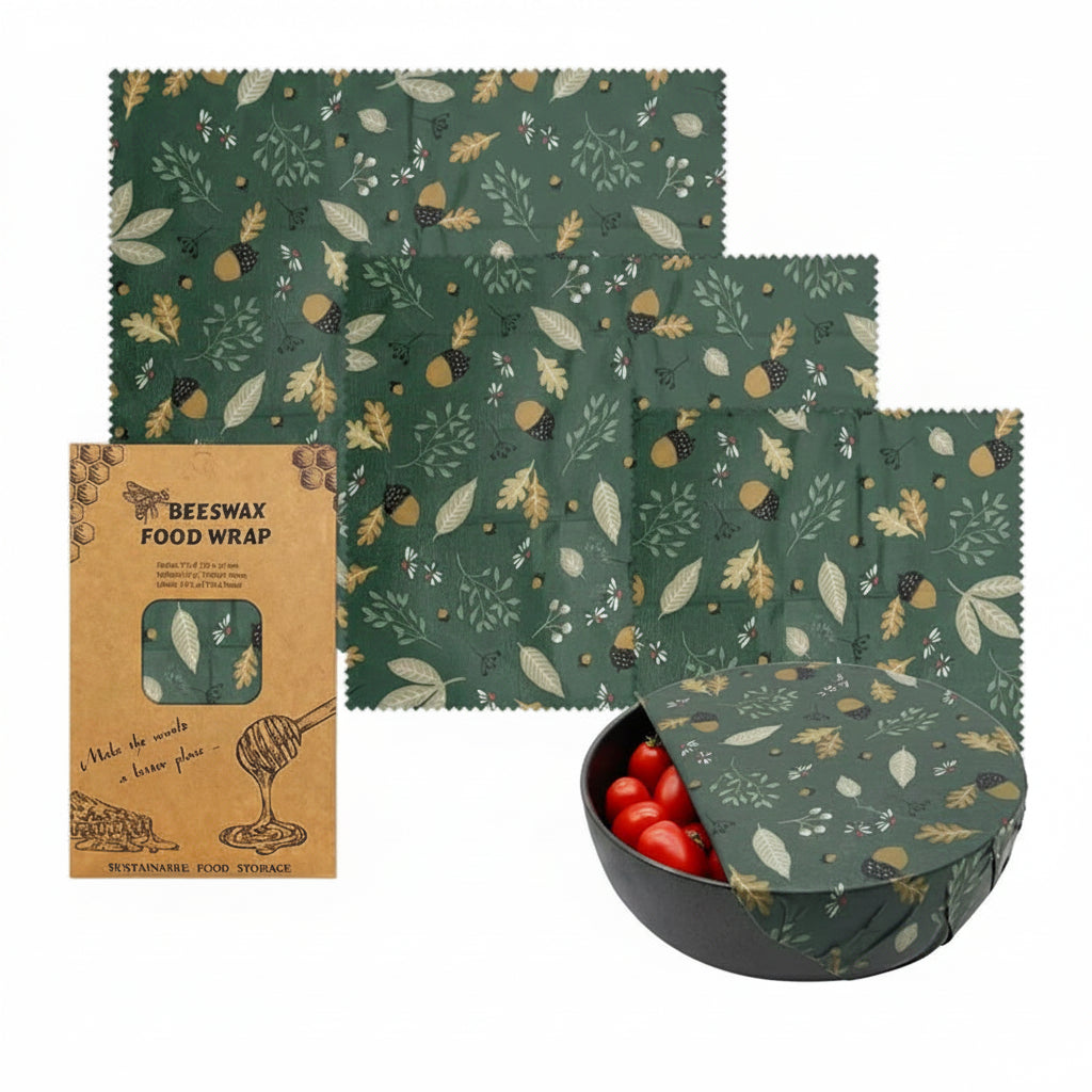 Beeswax food wrap set with three organic cotton covers in forest green autumn leaf pattern, shown with packaging and bowl of 