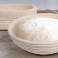 Natural rattan bread proofing basket with oval shape, featuring dusted flour and proofing dough inside, handmade banneton des