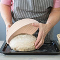 Natural rattan bread proofing basket being used to shape dough, showing handmade banneton craftsmanship for eco-friendly baki