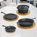 5-piece cast iron cookware set displayed on marble counter with wooden trivets, including skillets, Dutch oven, and griddle i