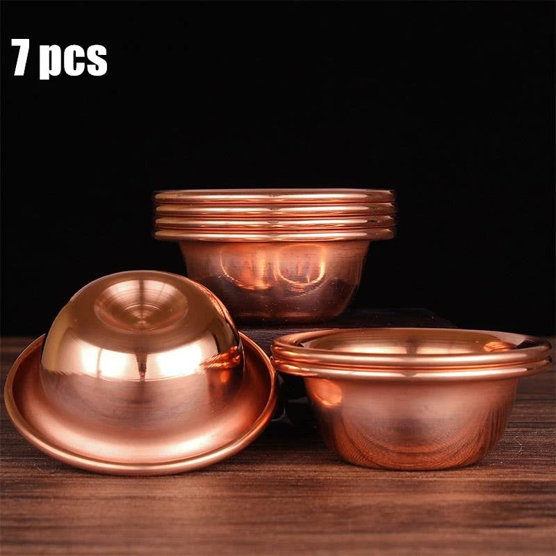 Seven copper dining bowls with lids displayed on wood surface, showing polished finish and traditional design for eco-conscio