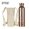 Copper water bottle 27oz with hammered finish and stainless steel cap, shown with cream canvas shoulder carry bag.