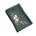 Organic cotton cleaning cloth in sage green with embroidered white daisies and brown stems, folded and displayed against whit