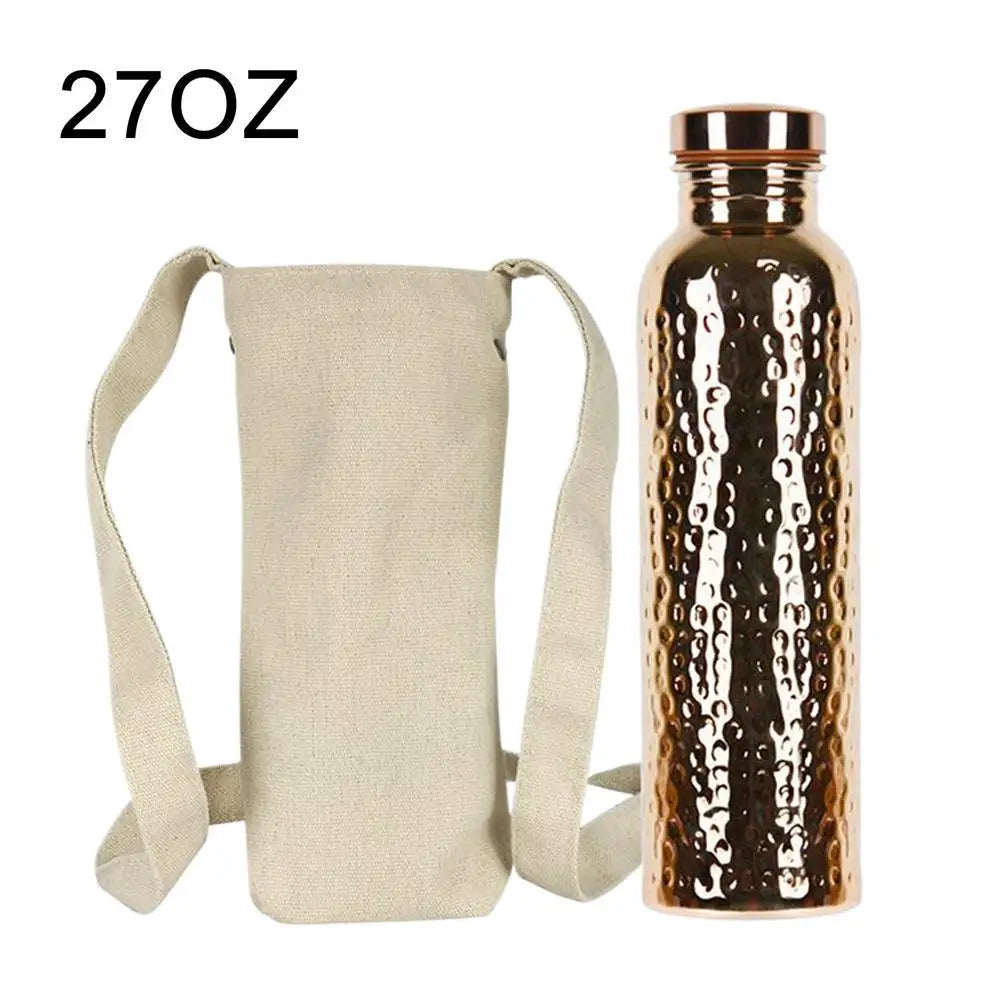 27oz copper insulated water bottle with hammered finish and rose gold cap, shown with beige canvas carrying case with shoulde