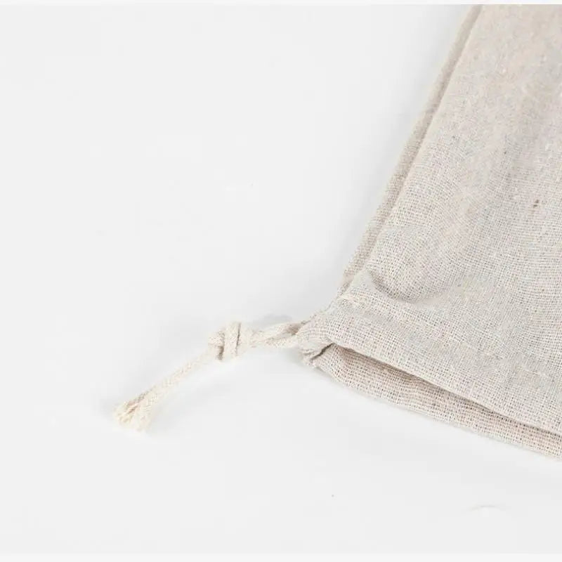 Handmade organic linen bread bag with frayed edges, natural beige color, displayed flat on white background.