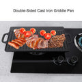 Double-sided cast iron griddle pan with griddled sausages, bacon, steak, and tomatoes on stovetop burners.