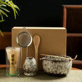 Japanese Matcha Bamboo Tea Set with ceramic bowls, bamboo whisk, wooden spoon, metal strainer, and glass matcha holder in kra
