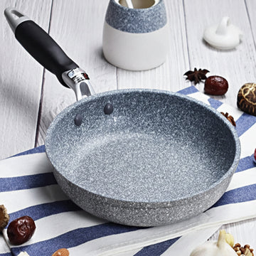 GraniteStone Fusion fry pan with gray granite non-stick coating, black handle, displayed on striped kitchen towel with decora