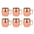 Set of 6 hammered copper Moscow mule mugs with brass handles and stainless steel interiors, arranged in two rows on white bac