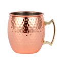 Hammered copper Moscow mule mug with stainless steel interior and brass handle, isolated on white background.